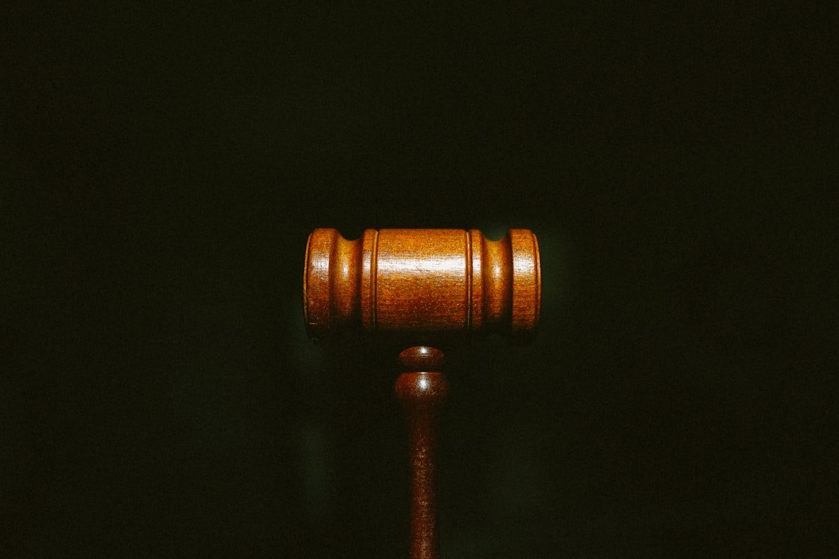 Wooden judge gavel on a dark background representing legal practice.
