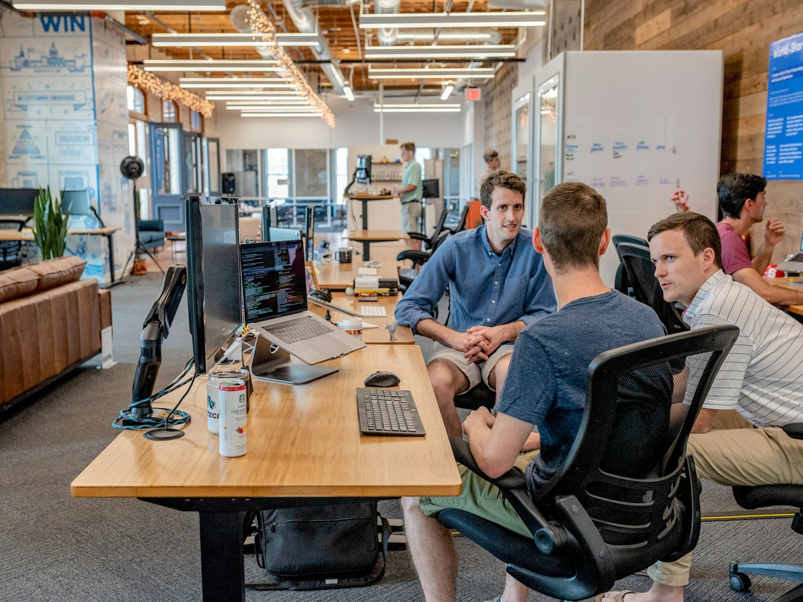 Technology team reviewing cloud rollout work in a bright office meeting room.