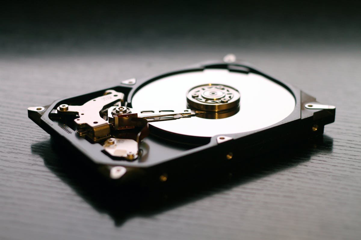 Open hard drive with visible platter and read arm for data recovery.