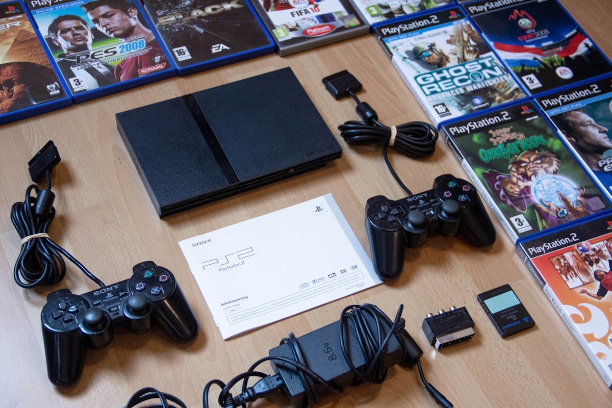 PlayStation console with controllers and games laid out on a table.
