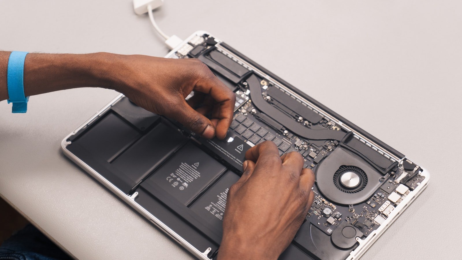 Person holding a MacBook during technical service.